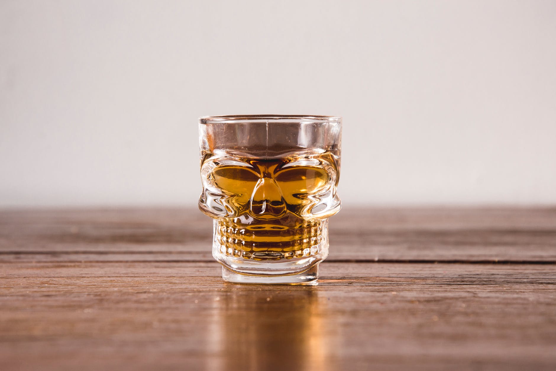 clear shot glass with yellow liquid